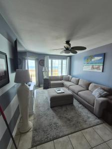 a living room with a couch and a ceiling fan at Grand Caribbean in Orange Beach