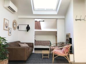 a living room with a couch and a skylight at La Mansarde du Port FAMILLY HOME in Nice