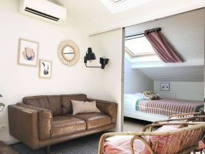 a living room with a couch and a bed at La Mansarde du Port FAMILLY HOME in Nice