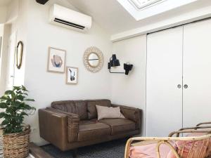 a living room with a brown leather couch at La Mansarde du Port FAMILLY HOME in Nice +43 photos