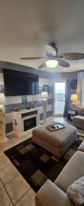 a living room with a couch and a tv at Grand Caribbean in Orange Beach