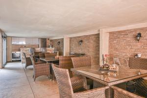 a dining room with tables and chairs and a brick wall at Apartmani Aleks in Budva