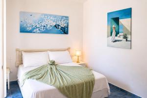 a bedroom with a bed and a painting on the wall at La Villetta Adults Only con giardino a Pula in Pula