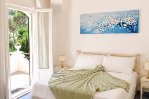 a bedroom with a bed with a painting on the wall at La Villetta Adults Only con giardino a Pula in Pula