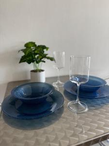 a table with two blue plates and glasses on a table at Estudio #2 a 5 min del malecon in La Paz
