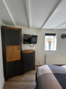 a bedroom with a bed and a flat screen tv at B&Beach Zandvoort in Zandvoort +3 photos