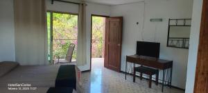 a bedroom with a bed and a desk with a television at Hotel San Carlos in Tizimín