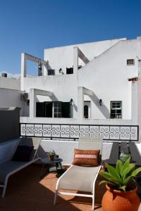 a patio with chairs and tables on a building at Townhouse with Rooftop Terrace in Olhão in Olhão