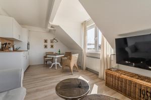 a living room with a table and a tv at Ferienwohnung Deichblick Quartier Pellworm in Pellworm
