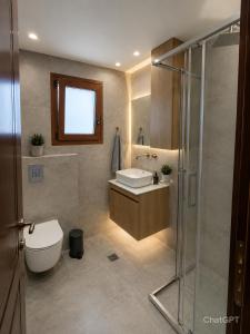 a bathroom with a toilet and a sink and a shower at Luxury Villa Evans 4BR Sleeps 8 Near Beach in Kokóni +67 photos