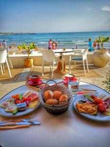 a table with plates of food on the beach at La Plage Boutique in Mangalia
