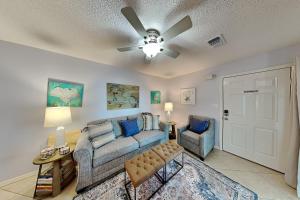a living room with a couch and a ceiling fan at Beachside Villas #413 in Seagrove Beach