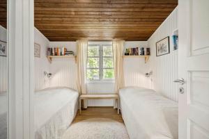 two beds in a small room with a window at 2236-Ringkobing-Fladsbjergvej-220 in Klegod