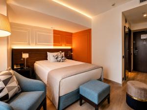 a bedroom with a bed and a chair and a couch at Handwritten Collection-Bucharest Unirii Square in Bucharest