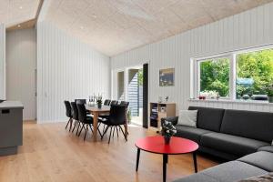 a living room with a couch and a table and chairs at OH591-Storvorde-Pilekrogen-15 in Skelby