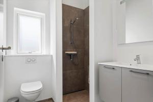 a bathroom with a toilet and a sink and a shower at OH591-Storvorde-Pilekrogen-15 in Skelby +12 photos
