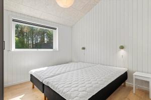 a bed in a bedroom with a window at OH591-Storvorde-Pilekrogen-15 in Skelby