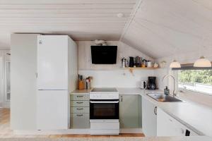 a kitchen with a white refrigerator and a sink at OH592-Hadsund-Haslevgaarde-Bakker-12 in Øster Hurup