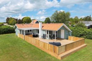 a house with a large deck in a yard at OH592-Hadsund-Haslevgaarde-Bakker-12 in Øster Hurup