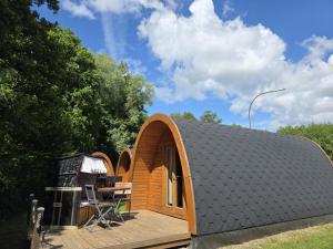 a small house with a deck and a table at 02 Premium Camping Pod "Langeneß" in Silberstedt