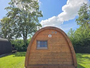 a small building with a window in the grass at 04 Premium Camping Pod "Oland" in Silberstedt