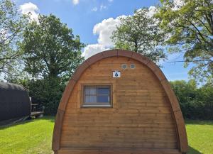 a small wooden building with a window in a yard at 06 Premium Camping Pod "Habel" in Silberstedt