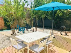 a white table and chairs with a blue umbrella at La maison Champollion in Albi