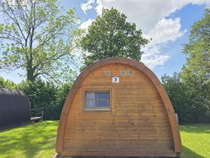 a small wooden building with a window in the grass at 07 Premium Camping Pod "Norderoog" in Silberstedt