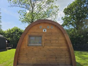 a small building with a window in the grass at 08 Premium Camping Pod "Süderoog" in Silberstedt