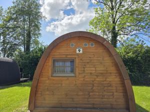 a small dog house with a window in a yard at 09 Premium Camping Pod "Hambuger Hallig" in Silberstedt