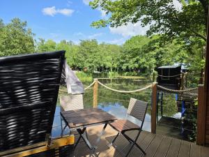 a deck with a table and chairs on a boat at 16 Premium Camping Pod "Bornholm" in Silberstedt
