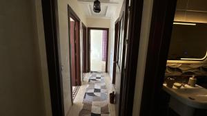 a hallway of a bathroom with a sink and a mirror at Appartement cosy in Agadir +15 photos