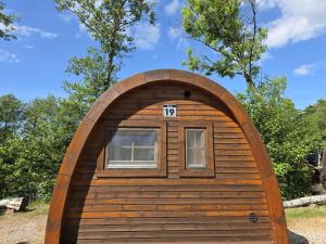 a small wooden cabin with a window in a field at 19 Premium Camping Pod "Alsen" in Silberstedt
