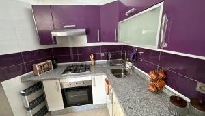 a purple kitchen with a sink and a stove at Appartement cosy in Agadir