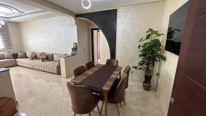 a living room with a table and a couch at Appartement cosy in Agadir