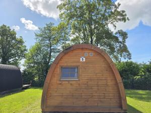 a small wooden building with a window in a yard at 05 Premium Camping Pod "Gröde" in Silberstedt