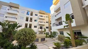 an apartment building with a palm tree in front of it at Appartement cosy in Agadir