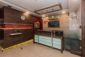 a room with a kitchen with a counter and a clock at Super Hotel O Solitaire in Turambhe