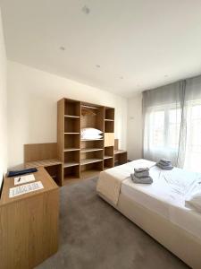 a bedroom with a bed and a desk and shelves at Velù Apartment in Porto Viro