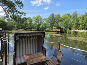 a house on the water with a table and chairs at 22 Premium Camping Pod "Norderney" in Silberstedt