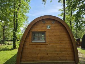 a dog house with a window in a yard at 28 Premium Camping Pod "Helgoland" in Silberstedt