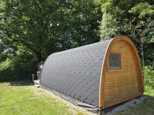 a small shed with a tin roof in a field at 00 Familien Premium Pods "Ebbe" in Silberstedt