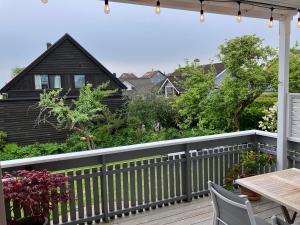 a wooden deck with a table and a house at Bright and central apartment in Stavanger