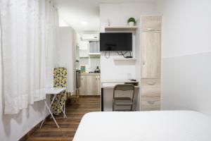 ein kleines Zimmer mit einem Bett und einer Küche in der Unterkunft Studio rent in Piura