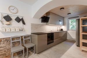 a kitchen with a counter and a clock on the wall at Chata Ve Stopě in Boží Dar