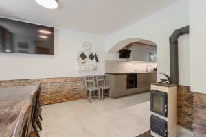 a large kitchen with a stone wall and a stove at Chata Ve Stopě in Boží Dar