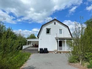 a white house with two trash cans in a driveway at Holiday Home in Ruda with Terrace in Ruda