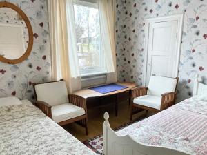 a room with two beds and two chairs and a window at Holiday Home in Ruda with Terrace in Ruda