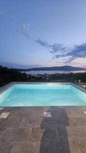 a large blue swimming pool with a view at Damisa Lux Stan in Tivat