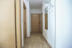 a hallway with white walls and wood flooring at Apartments Sesar in Rab